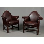 A pair of early 20th century leather upholstered camel back armchairs with brass studwork and raised