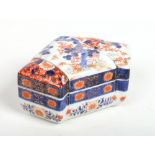 A Japanese Meiji period Imari box and cover of folded form. Painted with trees and stylized flowers.