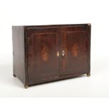 A Regency mahogany table cabinet. Crossbanded and raised on brass ball feet. Inlaid with a navette