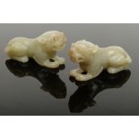 A pair of Chinese Qing dynasty celadon jade temple dogs. Each carved in a recumbent pose, showing