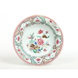 A large 18th century Chinese famille rose dish. Painted to the centre with peonies, a fan and a vase