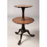 A Georgian mahogany two tier centre pedestal dumb waiter. With dished circular tiers and raised on