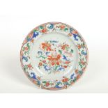 An 18th century Chinese plate. Painted in coloured enamels with flowers under a lambrequin border,