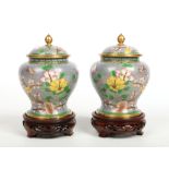 A pair of 20th century Chinese cloisonne ginger jars and covers of baluster form raised on carved