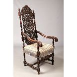 A Victorian baronial style oak armchair. With a pierced backrest adorned with flowers and scrolls,