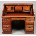 An early Victorian panelled mahogany roll top desk with hinged wings and fully fitted interior