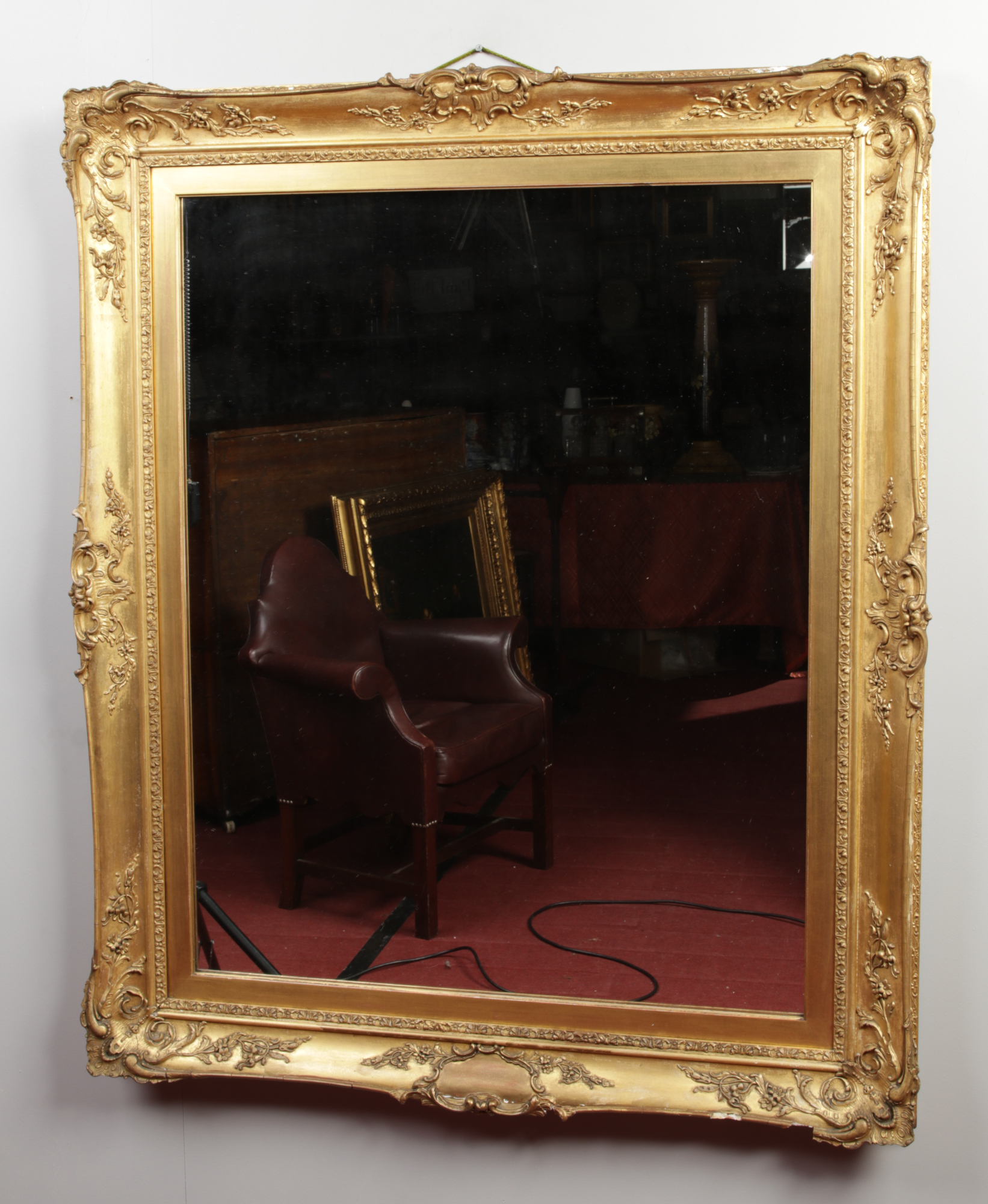 A wall mirror in ornate swept gilt frame, 118cm x 97cm.Condition report intended as a guide only.