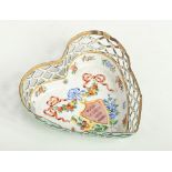 An 18th century English enamel heart shaped dish with pierced sides. Decorated with a shield bearing