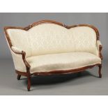 A Victorian carved rosewood two seat parlour settee. With cream silk upholstery and raised on