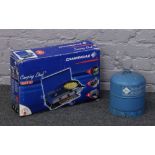 A boxed camping gas portable stove along with empty gas bottle.