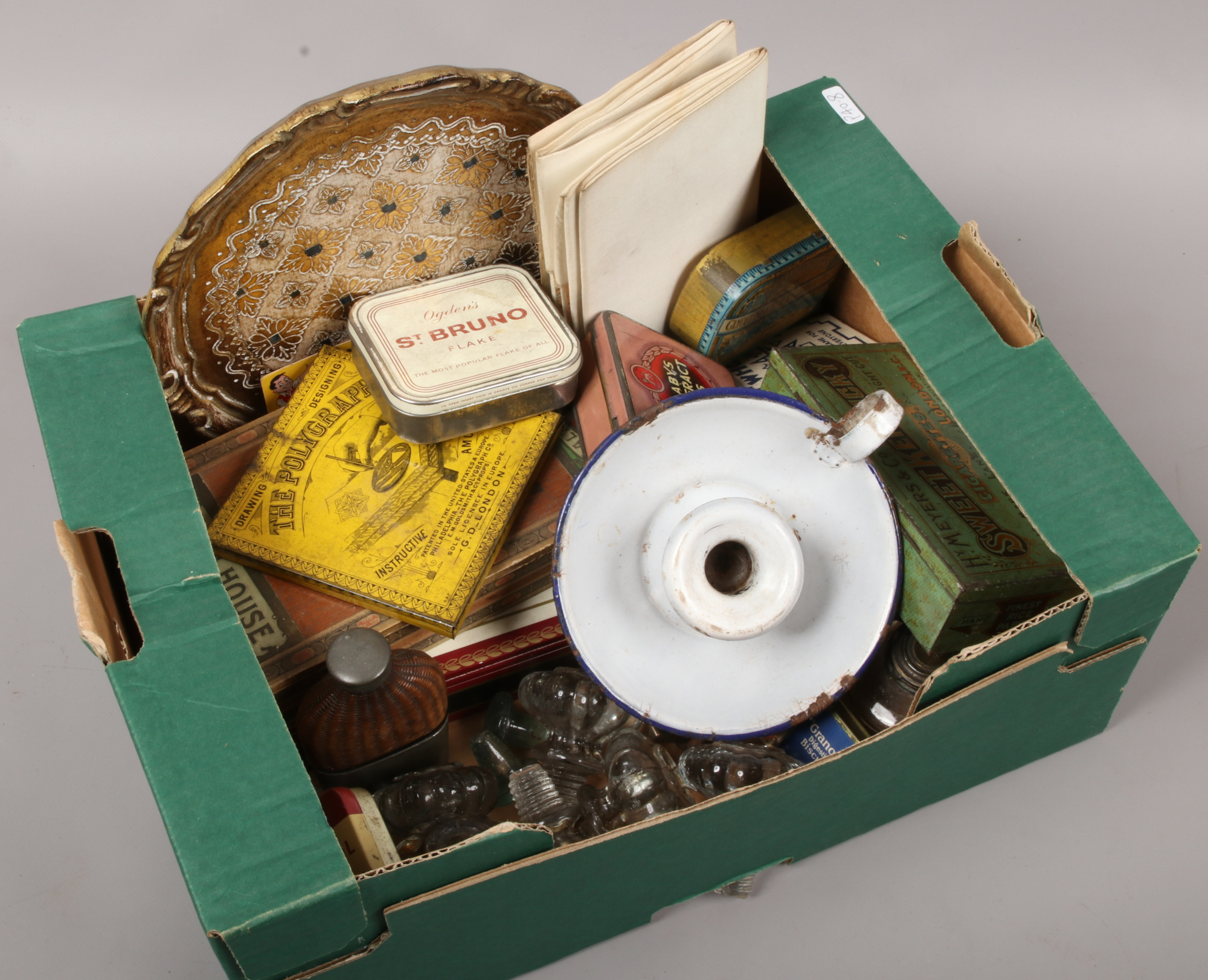 A box of collectables including advertising tins, glass drawer pulls, cigar boxes, playing cards,