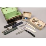 A vintage painted tin case box and contents of barbers accessories including cut throat razors,