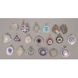 A collection of silver medals and badges to include enamel examples.