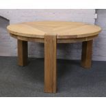 A large light oak circular Helcinky rustic dining table and a natural wood care kit.