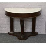 An Edwardian mahogany marble top demilune side table raised on lion paw feet supports.