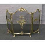 An ornate brass three fold fire guard.