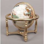 A revolving table globe and compass to base raised on a turned brass stand.