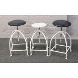 Three Industrial style adjustable stools with white painted steel frames.