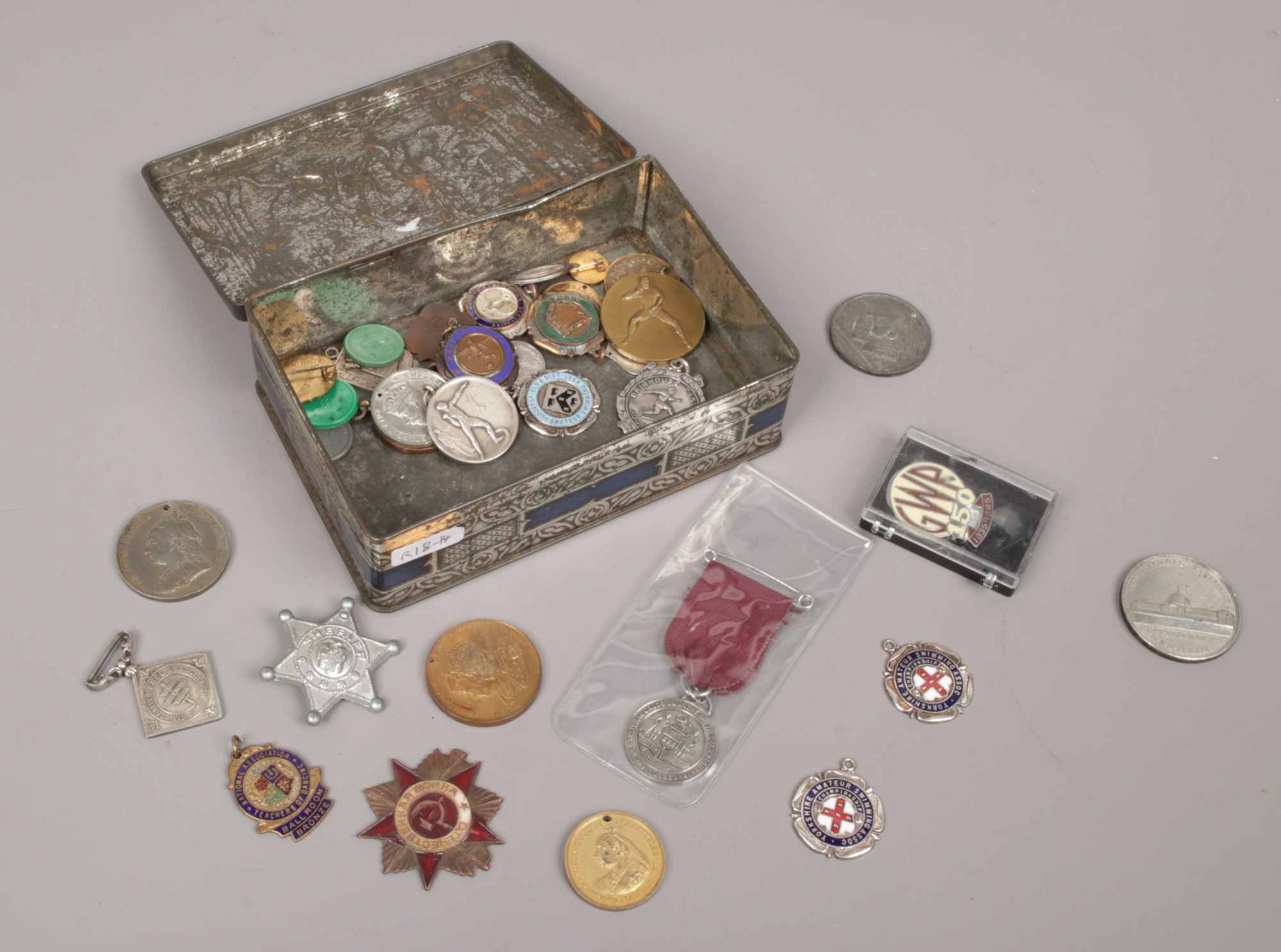 A tin of various medals to include enamel examples.