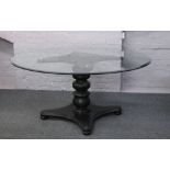 A large circualr glass centre pedestal table along with four iron chairs with scroll decoration,