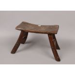 A period oak estate built small stool. With concave plank top, exposed tenons and splay supports,