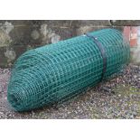 An almost full roll of plastic coated steel fencing 4' high.