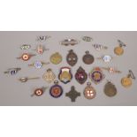 A collection of medals and badges to include enamel examples.