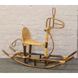 A vintage bamboo rocking horse with canework seat.