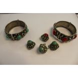 Two white metal bangles, with red and green cabochons, three similar earrings and a ring