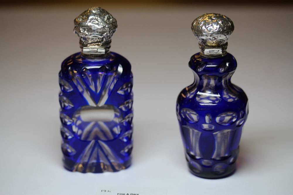 Two Victorian white metal (thought silver) mounted blue flashed and cut glass scent bottles,