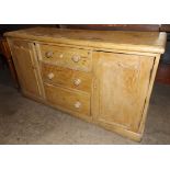 Victorian Pine Dresser Base with Three Central Drawers Flanked by Two Panelled Doors on a Skirt Base