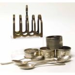 Four silver napkin rings, four teaspoons and a toast rack. No condition reports for this sale.