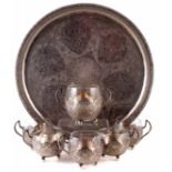 A Turkish circular silver tray, decorated with intricate floral designs and scrollwork, inset with