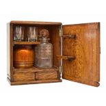 A small 20th century oak art deco drinks cabinet. Containing a pressed glass decanter and four