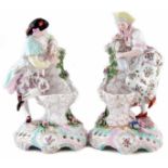 Pair of Dresden porcelain figures, modelled as a lady and gentleman standing beside water fountains,