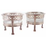 A pair of French silver salts,clear glass liners, with pierced scrolling decoration on tripod