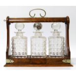 Three bottle tantalus with oak frame EPNS We are unable to provide condition reports for this sale.