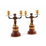 A pair of French rouge marble twin branch candlesticks. Each one has a faun supporting the branches.