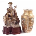 Japanese Satsuma figure of a female musician modelled seated on a lotus leaf throne, with wood base,