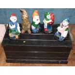 Wooden box containing five painted gnomes We cannot do condition reports for this sale.