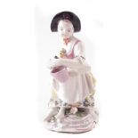 Bow porcelain figure circa 1762, modelled as a female a grape vendor, modelled on scrolled base,