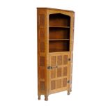 In the style of "Mouseman" there being no trademark mouse, floor standing corner cabinet, three open