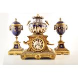 A late 19th century French ormolu and ceramic mantel clock and garnitures. The central clock is