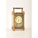 A late 19th century French champleve carriage clock. Fluted brass columns frame an enamel dial