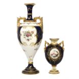 Two Coalport twin handled lidded vases, decorated with landscapes within gilt cartouches on blue and