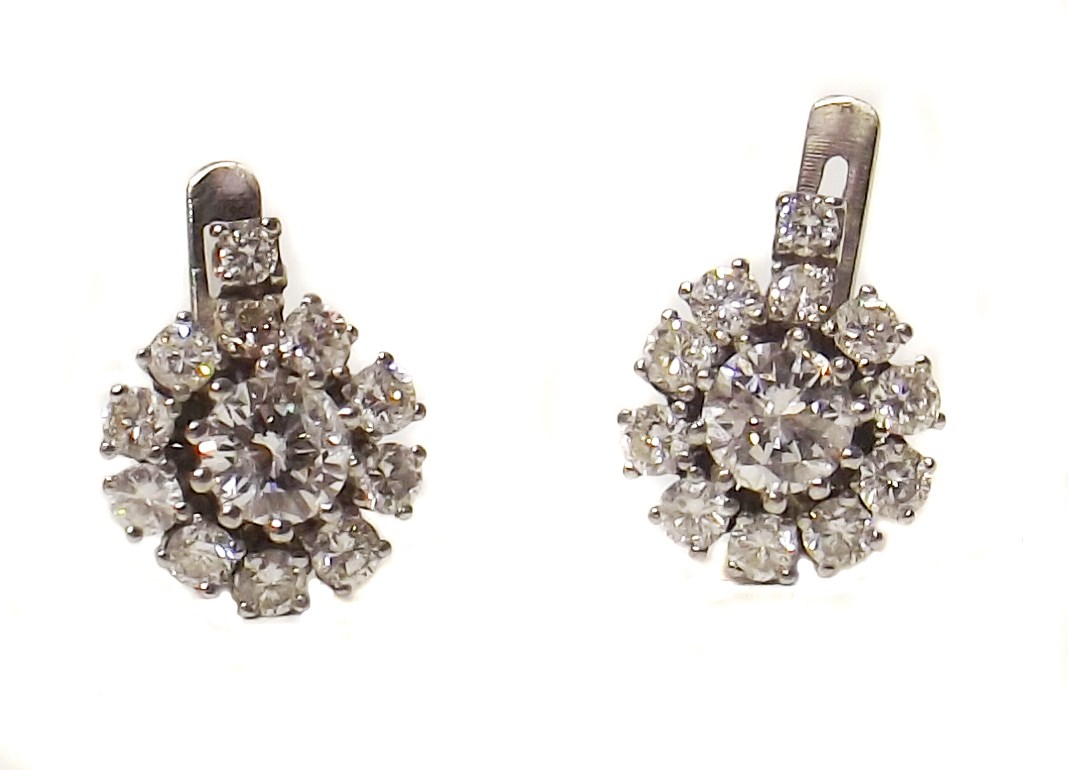 Pair of diamond cluster white gold stud earrings , the two central brilliant cut diamond weighing