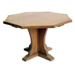 In the style of "Mouseman", octagonal pedestal dining table adzed top on support with four brackets,