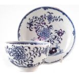 Lowestoft tea-bowl and saucer circa 1775, painted with a rare under-glaze blue flower and rock