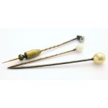 A hat pin with a diamond inset, approx. 0.33ct, and two other hat pins Unfortunately we are not