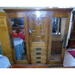 An arts and crafts style ash double mirror door wardrobe, the centre portion enclosing dressing